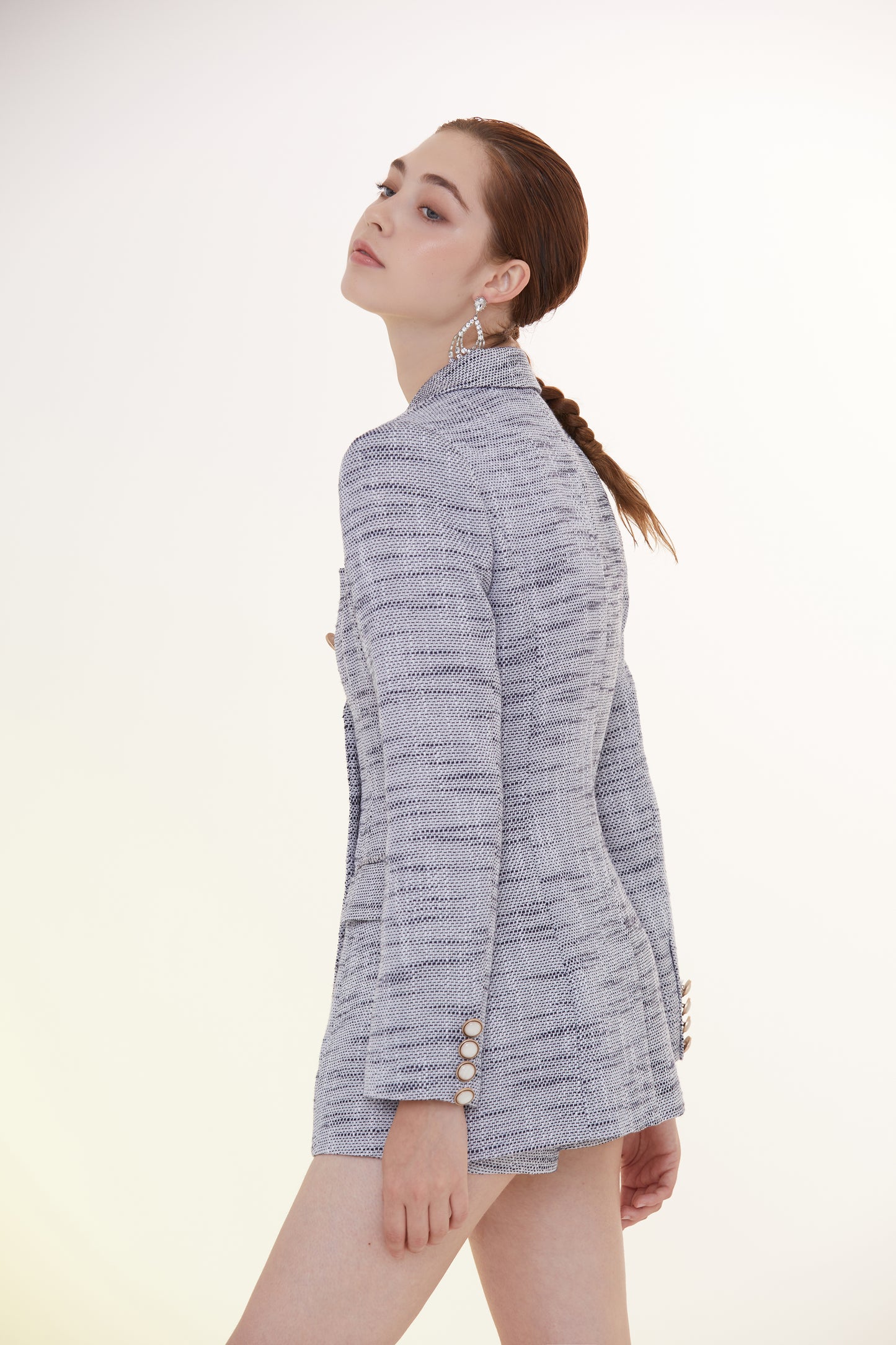 a woman standing in front of a white wall