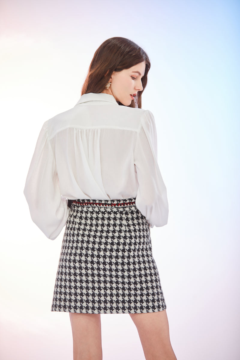 a woman standing in front of a white dress